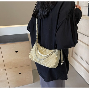 Détail du sac bandoulière vert pâle froncé avec perles et chaînes en métal argenté
