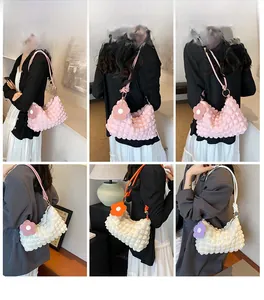 Detail shots of pink and cream bubble texture underarm bag with flower charm on model
