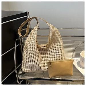 Detail of beige hollow woven tote bag with leather straps and matching inner pouch