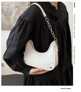 Detail of white crescent bag showing silver chunky chain strap and rivet embellishments
