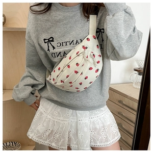 Detail of cream corduroy crossbody bag with red strawberry print and zipper pull