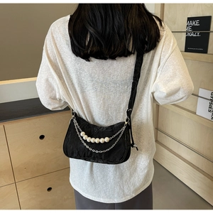 Détail du sac à bandoulière froncé noir avec perles élégantes et chaînes en métal argenté