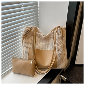 Macro detail of beige woven straw tote bag with brown leather straps and inner pouch