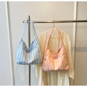Detail of colorful striped canvas tote bags in blue-purple and pink-orange color options