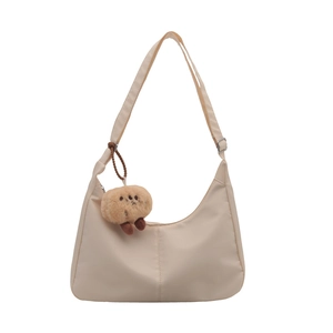 Minimalist beige oxford nylon crescent shoulder bag with a cute plush cookie charm accessory