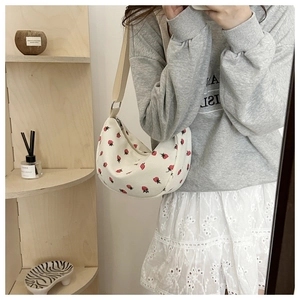 Detail of floral corduroy crescent bag with strawberry print and fabric shoulder strap