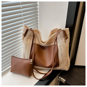 Detail of handwoven straw tote with premium brown leather patch and matching inner pouch