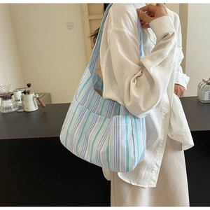 Detailed side view of a striped canvas tote bag with functional multi-pocket design