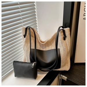 Detail view of woven straw tote bag with black leather panel and matching pouch