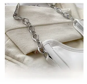 Detail of silver chain link and stitching on minimalist white leather baguette bag