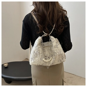 Close-up of white plush tote bag with butterfly print and silver multi-layer chain detail