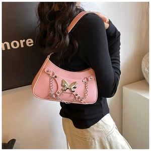 Primer plano del bolso de hombro Y2K rosa con detalle de mariposa metálica y cadena