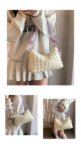 Detail of white bubble texture bag with purple straps and flower pendant ornament