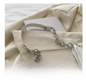 Close-up of crescent bag with white leather texture and bold silver chain strap detail