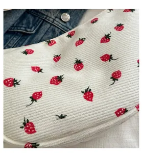 Detail shot of white corduroy shoulder bag with sweet red strawberry embroidery patterns