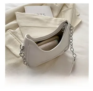 Spacious interior of white crescent shoulder bag showing wallet and cosmetics capacity