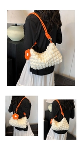 Detail of white bubble texture tote with vibrant orange rope handle and flower charm