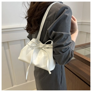 Close-up of minimalist white underarm bag with a delicate bow detail for commuters