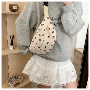 Detail of strawberry pattern corduroy crossbody bag with adjustable black buckle strap