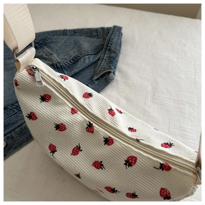 Detailed macro view of cream corduroy material with red strawberry floral patterns