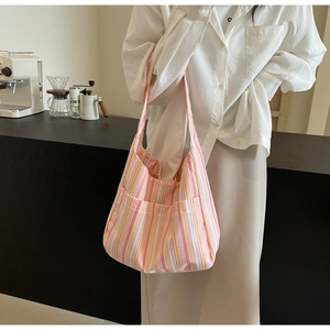 Detailed shot of large striped canvas tote bag with front pockets and wide shoulder strap