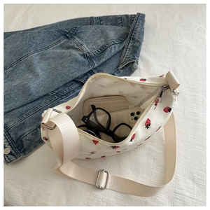 Interior view of white strawberry corduroy bag showing capacity for phone and wallet