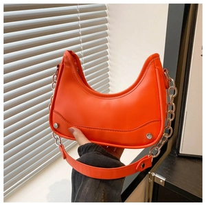 Detail view of orange moon bag with silver chain and metal studs on premium PU leather