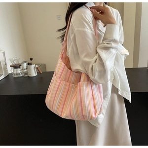 Close-up of vibrant striped canvas tote showing colorful fabric texture and front pockets