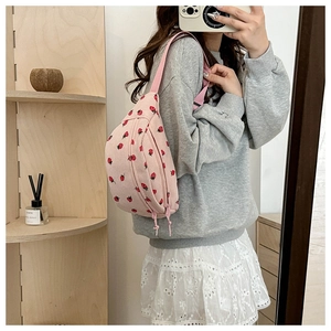 Pink corduroy crossbody bag with red strawberry print and double zipper details