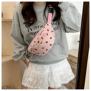 Detail of pink corduroy saddle bag with strawberry pattern and adjustable strap