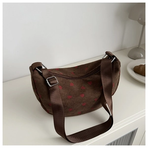 Detail of brown corduroy crescent bag with strawberry print and adjustable strap