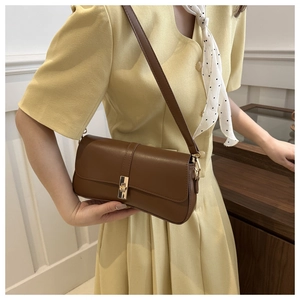 Détail d'un sac à bandoulière en cuir marron avec fermoir rotatif en métal doré chic