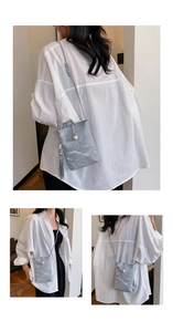 Detailed view of grey textured mini phone bag with pearl charm and long tassel accent