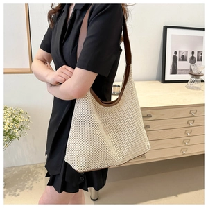 Close-up of beige woven tote bag with premium brown leather straps and detailed texture