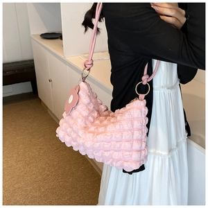Detailed shot of pink bubble texture shoulder bag with floral charm on model