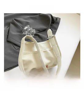 Detail view of the sleek white leather hobo bag featuring a wide strap and silver buckle