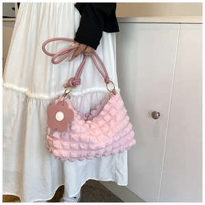 Detailed texture of pink bubble pleated hobo bag with floral charm and gold hardware