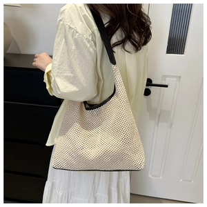 Hobo style straw woven tote bag in cream white with black contrast shoulder straps
