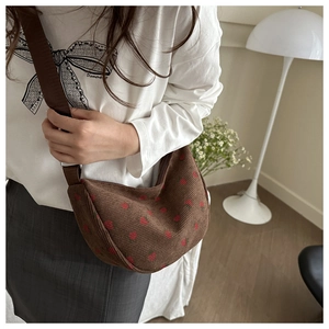 Detail of brown corduroy crossbody bag with strawberry print and adjustable strap