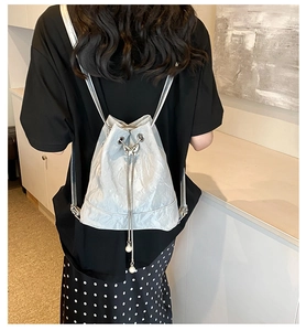 Detail of silver drawstring bucket bag with butterfly metal lock and pearl accents