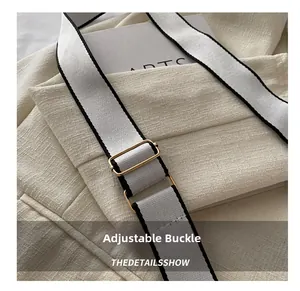 Macro detail of golden adjustable metal buckle and dual-color woven crossbody strap
