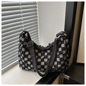 Détail du sac bandoulière à damier noir et blanc avec une texture à bords effilochés