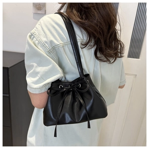 Dettaglio della borsa a secchiello nera con coulisse e fiocco per texture e misura
