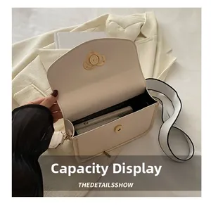 Inner storage detail of cream PU crossbody bag with elegant heart twist lock and strap