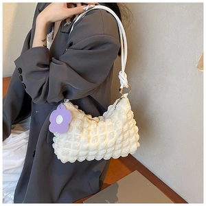 White pleated underarm bag featuring a purple flower charm and gold hardware detail