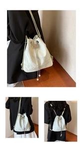 Detail of mint green bucket bag featuring metal butterfly charm and pearl drawstring accents
