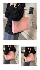 Detail of pink leather tote bag with gold logo and long shoulder straps for daily commute
