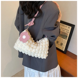 Detail of white bubble cloud bag with pink braided rope strap and 3D floral charm