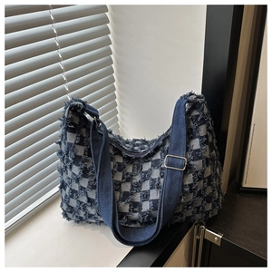 Détail du sac en denim à damier bleu et blanc avec bords effilochés et bandoulière réglable