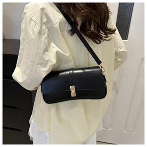 Détail du sac sous le bras noir minimaliste avec fermoir métallique doré et cuir PU